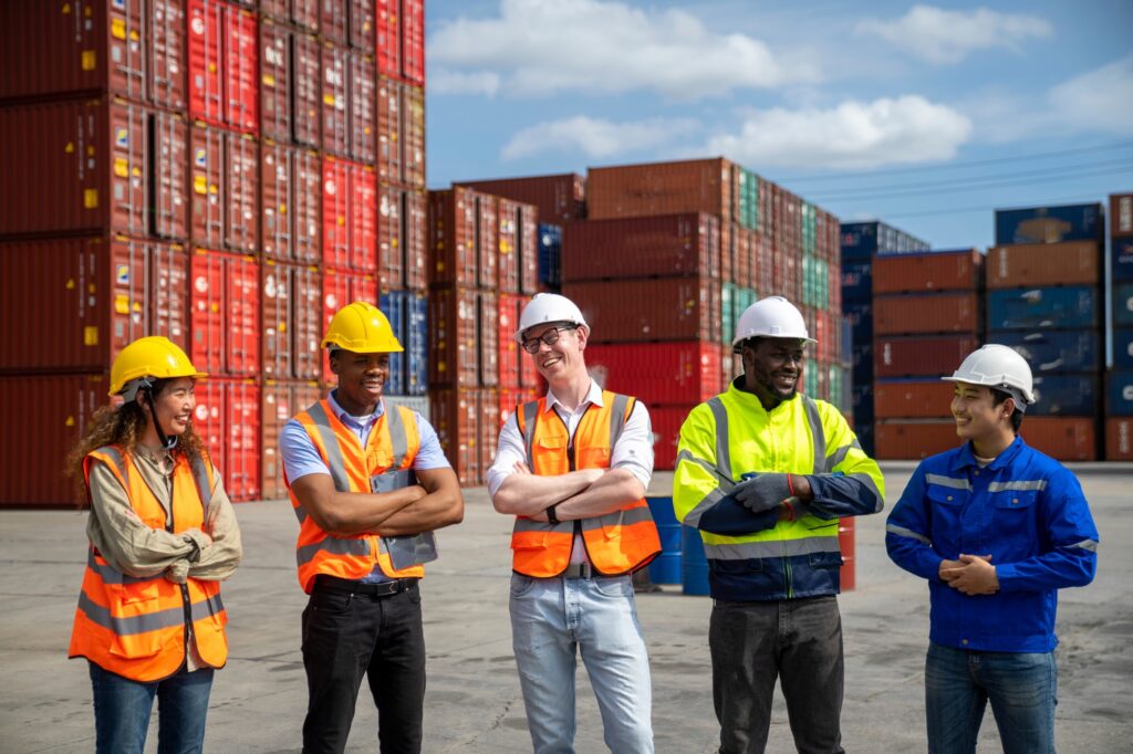 Group of engineer worker and manager standing in the shipping yard container.